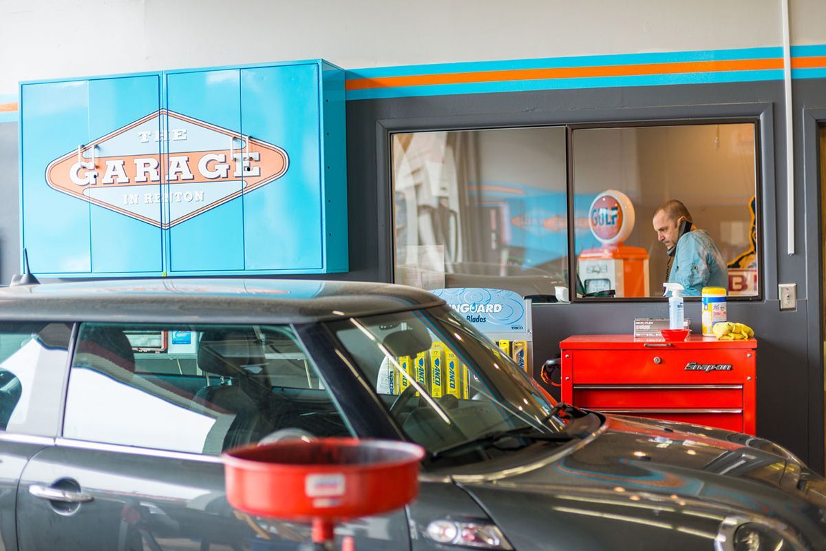 A man is working on a car in a garage. | The Garage in Renton