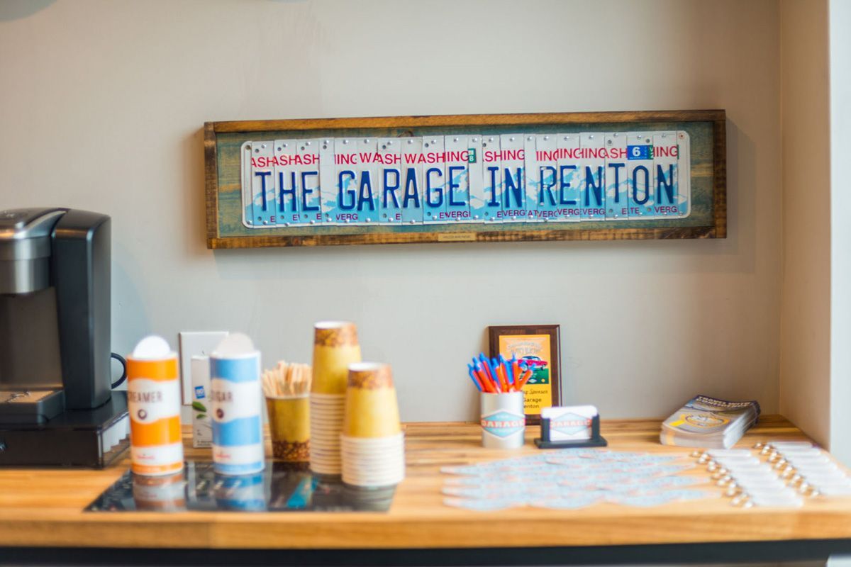 There is a sign on the wall above the counter that says `` the garage in renton ''. | The Garage in Renton