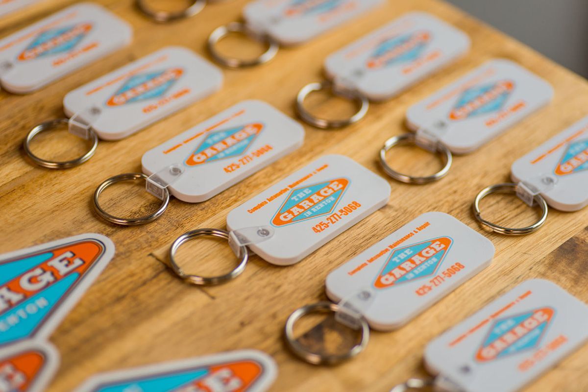 A bunch of keychains are sitting on a wooden table. | The Garage in Renton