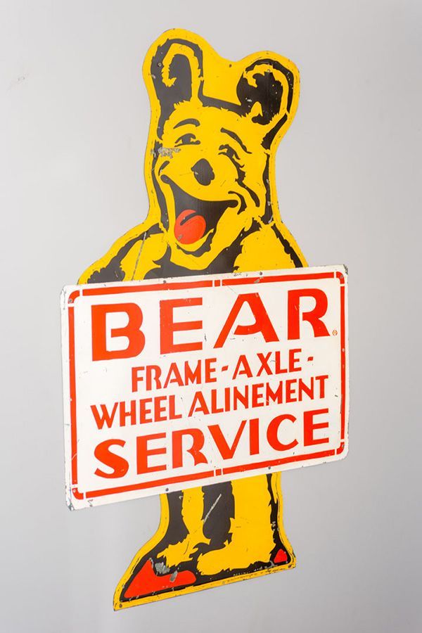 A bear holding a sign that says bear frame axle wheel alignment service | The Garage in Renton