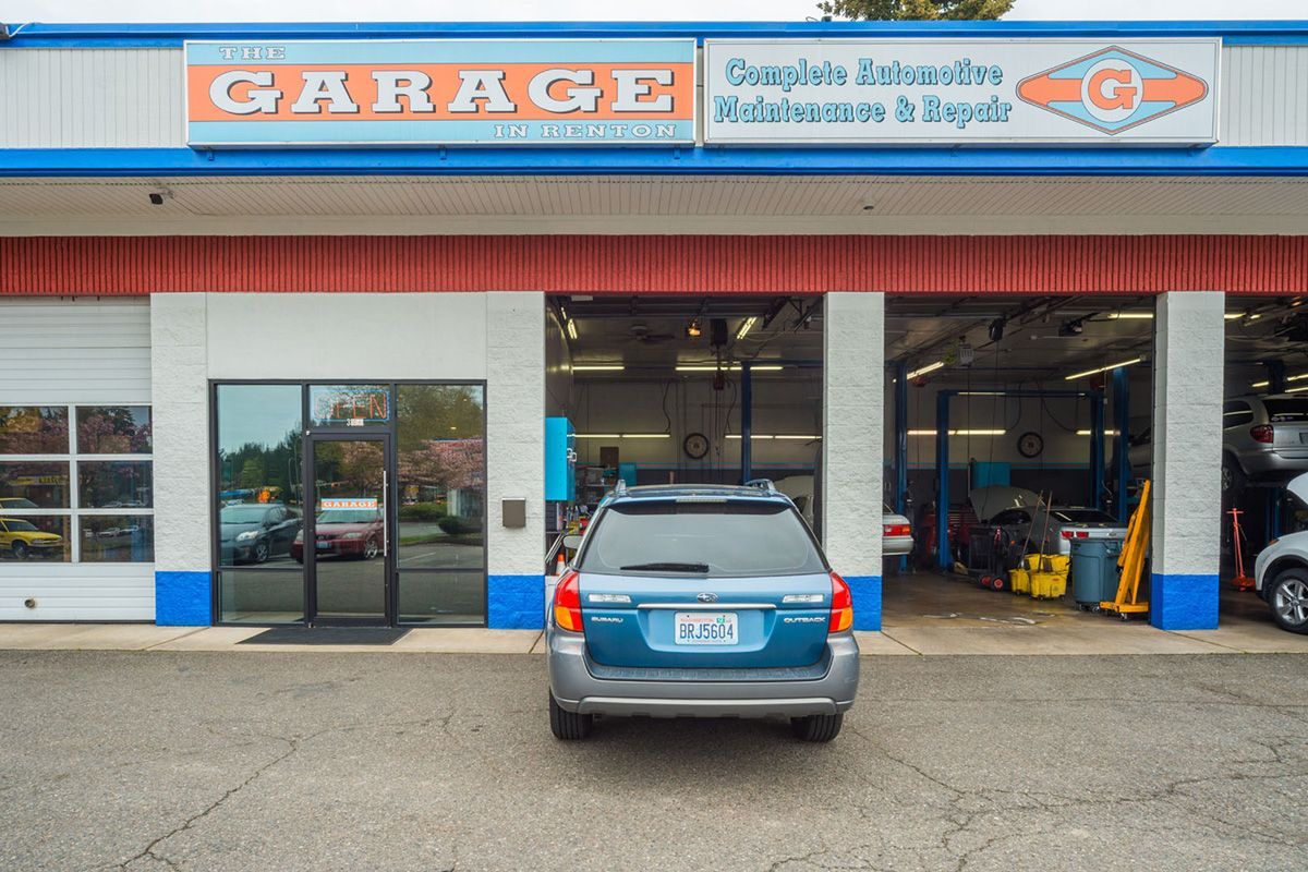 A blue suv is parked in front of a garage. | The Garage in Renton