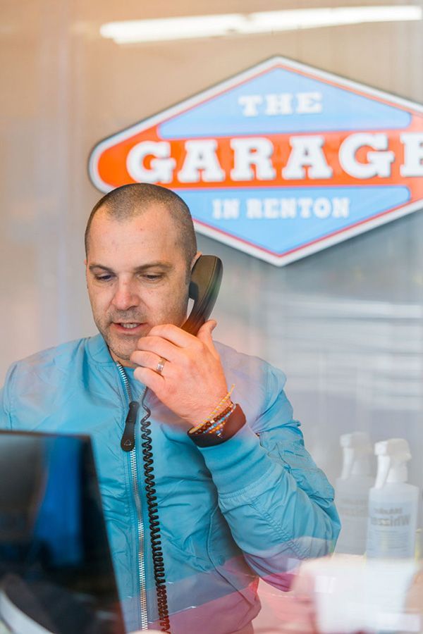 A man is talking on a phone in front of a computer. | The Garage in Renton