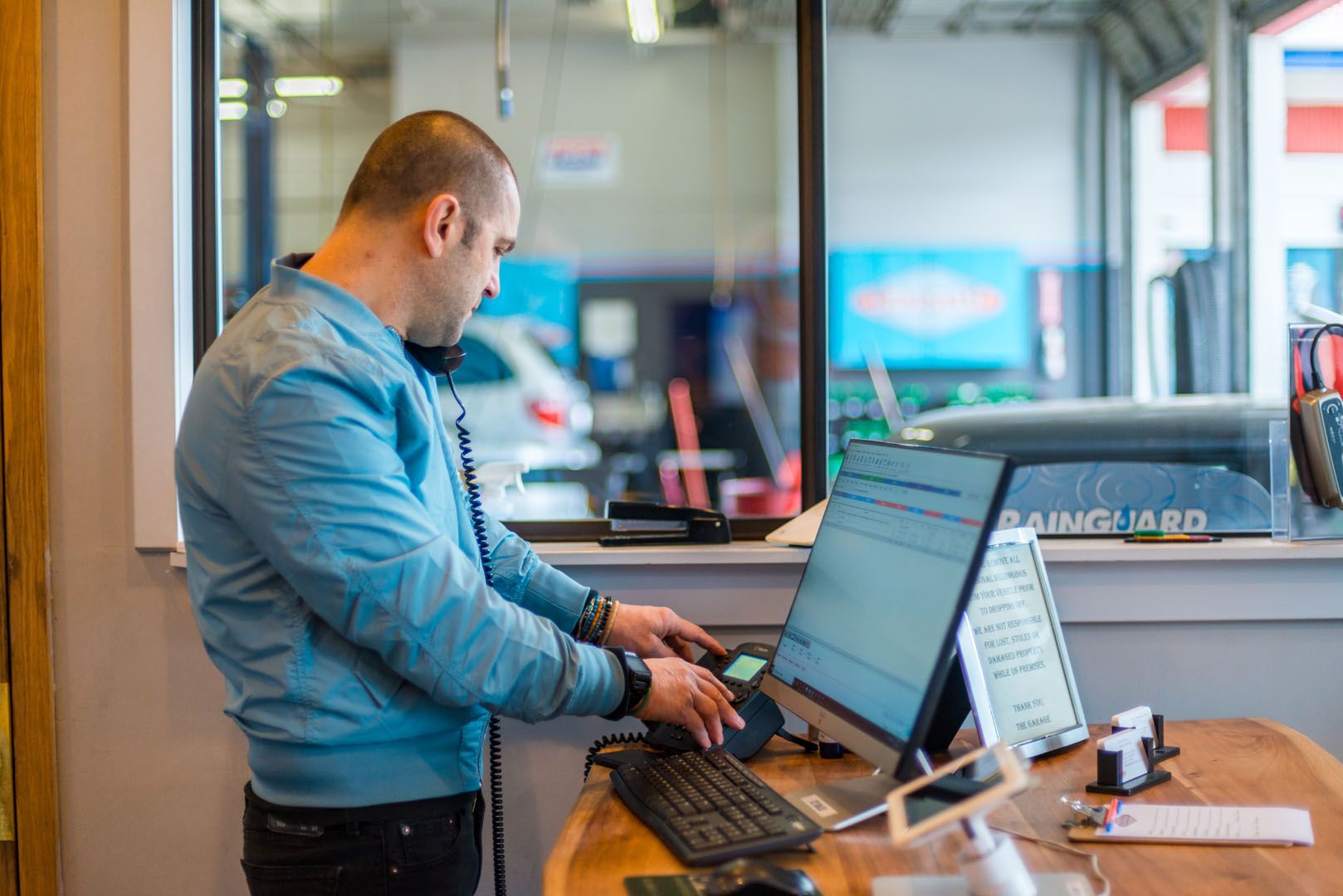 A man is standing in front of a computer in a garage. | The Garage in Renton