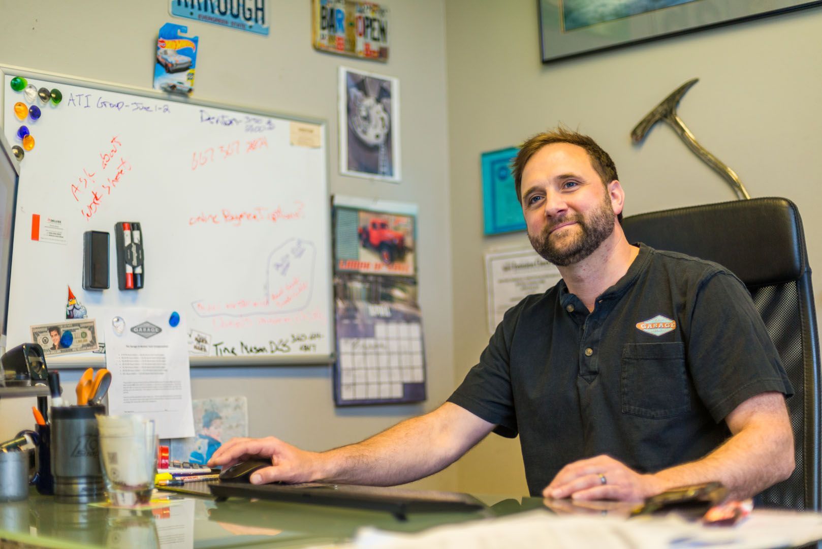 A man is sitting at a desk in front of a whiteboard. | The Garage in Renton
