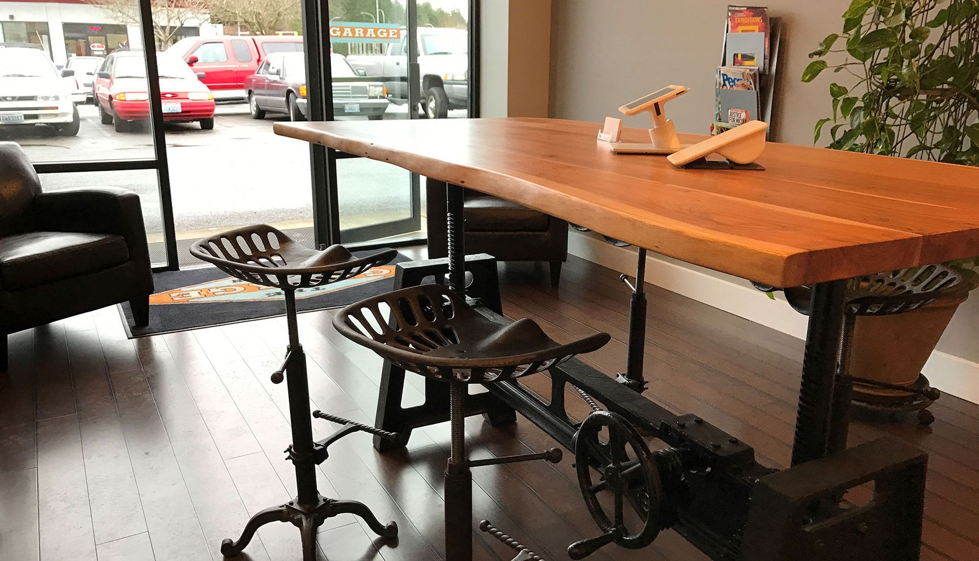 A wooden table with two stools underneath it in a room | The Garage in Renton