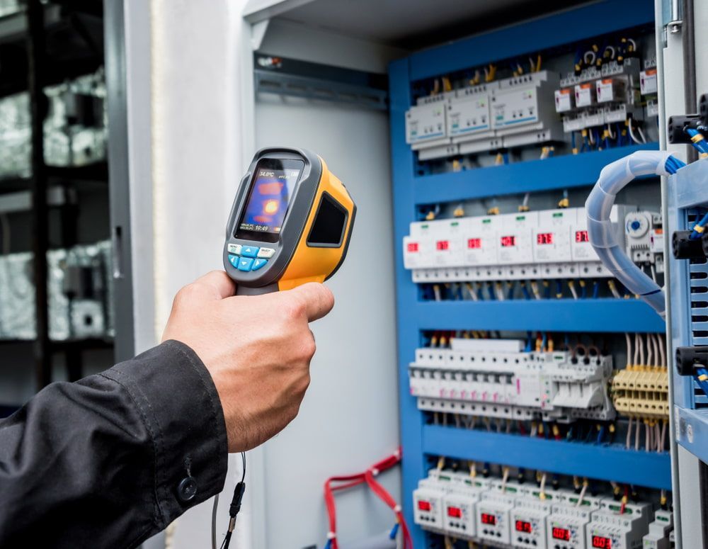A Person Using a Thermal Camera to Inspect an Electrical Panel — Aurablue Electric in Fullerton Cove, NSW