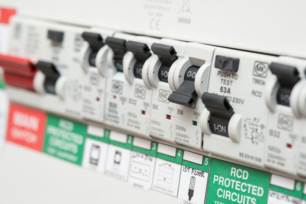 A Close-up of a White Electrical Fuse Box With Several Black Switches in the on Position — Aurablue Electric in Fullerton Cove, NSW