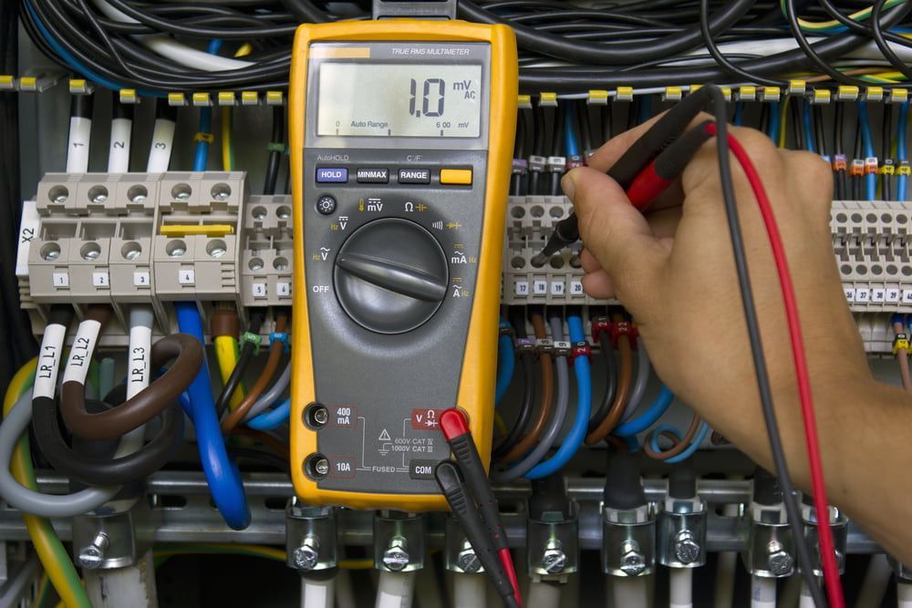 A Person is Using a Multimeter to Test a Circuit Board — Aurablue Electric in Fullerton Cove, NSW