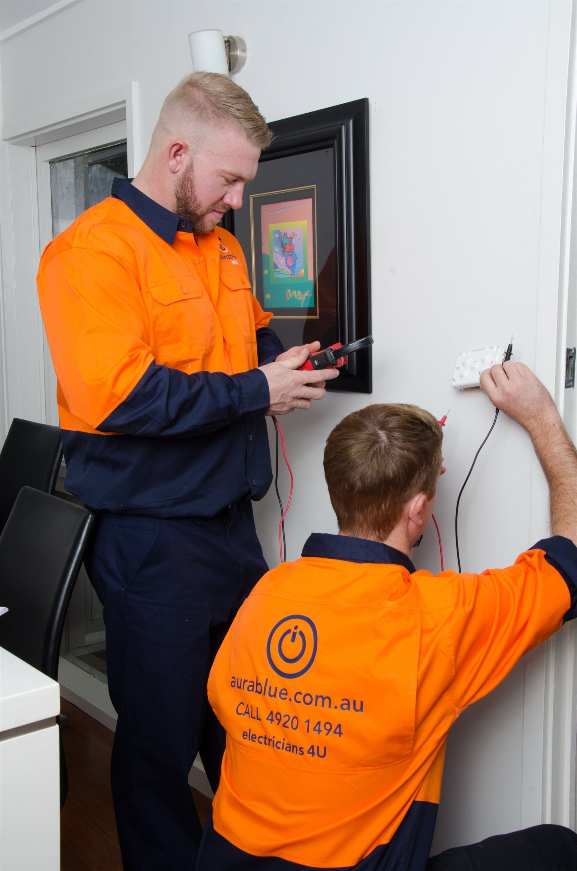 A Aurablue worker is wiring a light switch wearing uniform — Aurablue Electric in Fullerton Cove, NSW