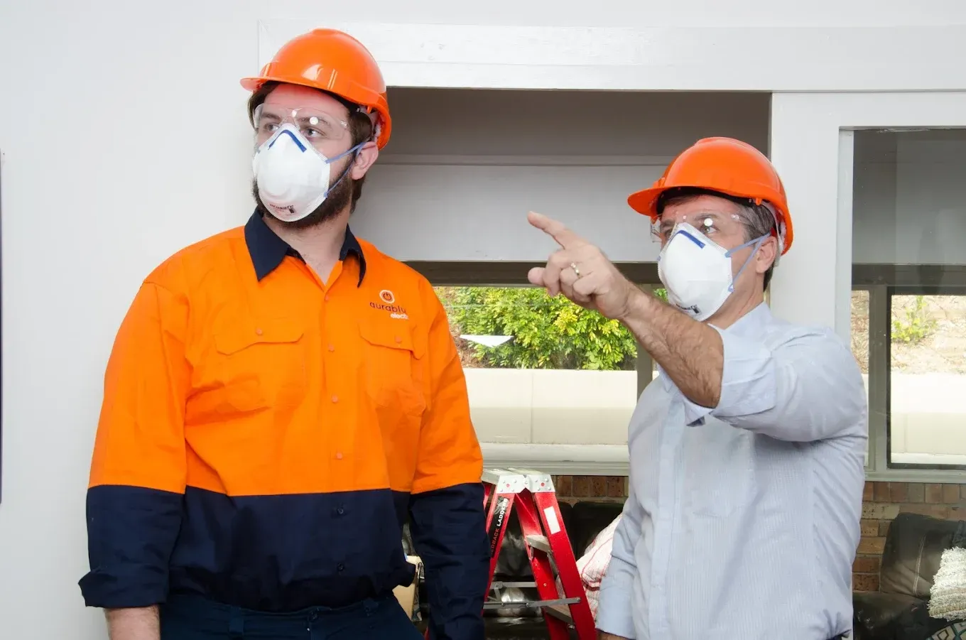 Two workers are having a conversation while wearing hard hat, glasses and mask — Aurablue Electric in Fullerton Cove, NSW