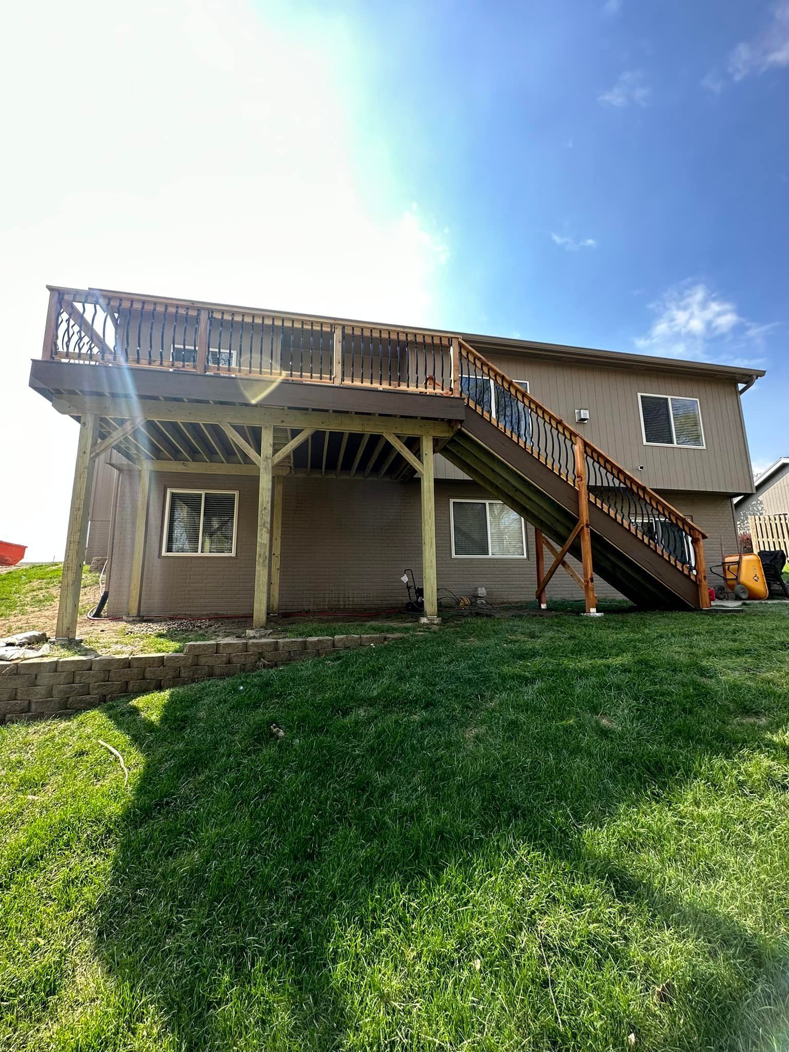 A house with a large deck and stairs in the backyard.
