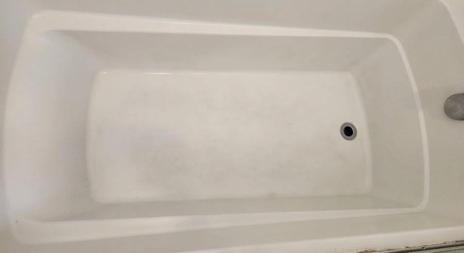 Empty white bathtub with drain and faucet visible.