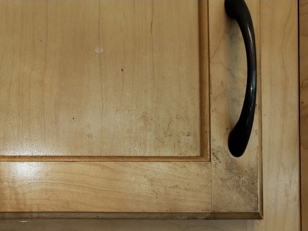 Wooden kitchen cabinet with a black handle.