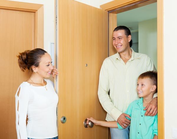 A family is standing in front of a door talking to each other. A family is standing in front of a door talking to each other.