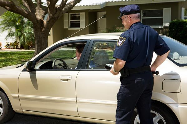 A police officer is standing next to a white car