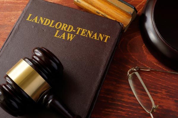 A book titled landlord-tenant law sits on a wooden table A book titled landlord-tenant law sits on a wooden table