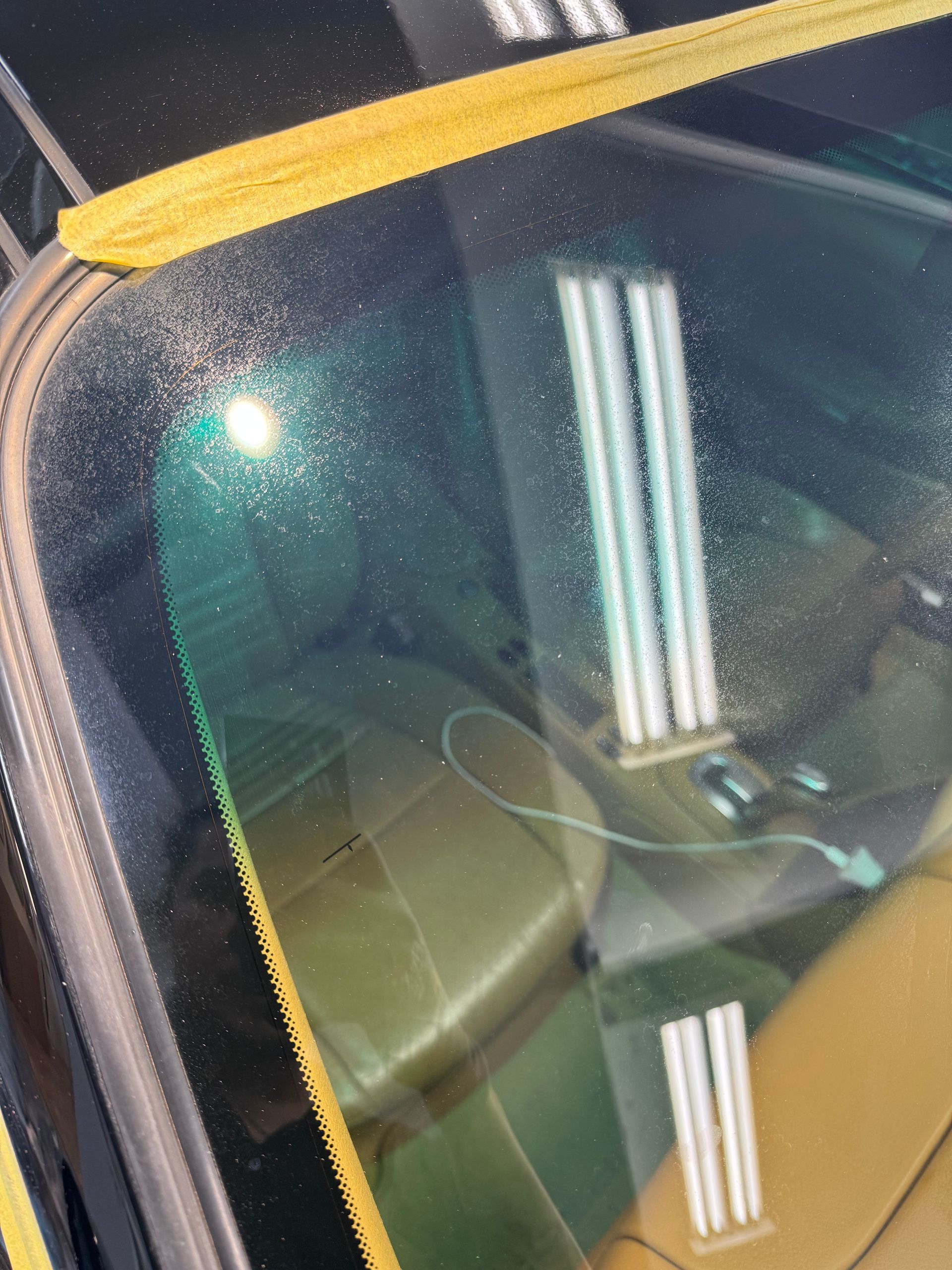 Porsche rear glass before — water spot etching and contamination