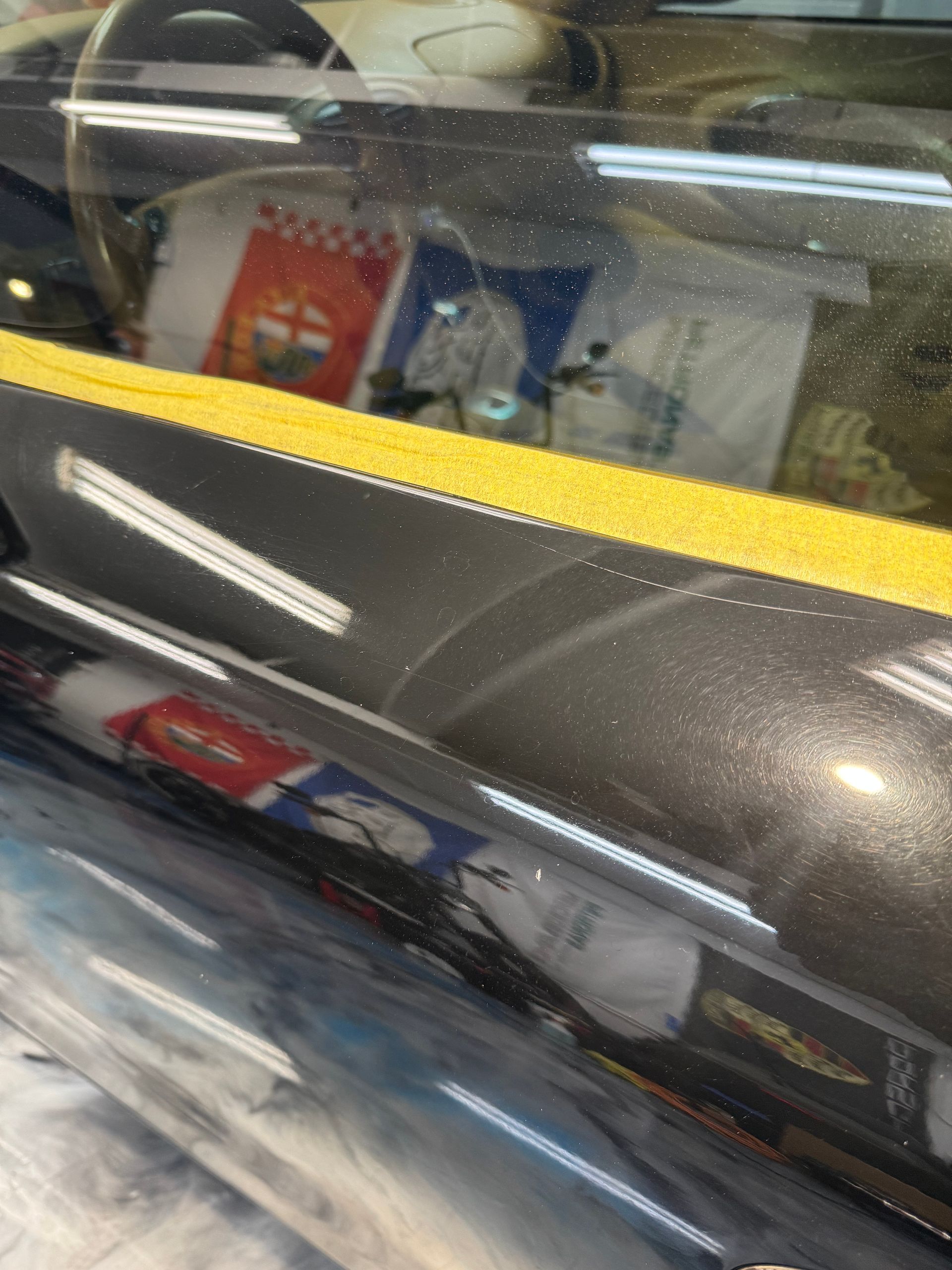 Porsche panel before paint correction — swirl marks visible under inspection light