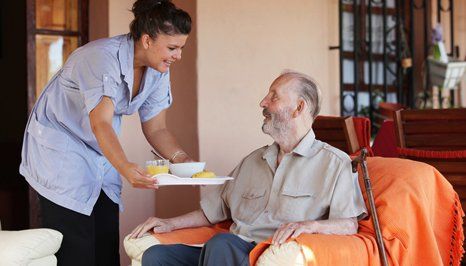 carer offering food for an elderly in-mate