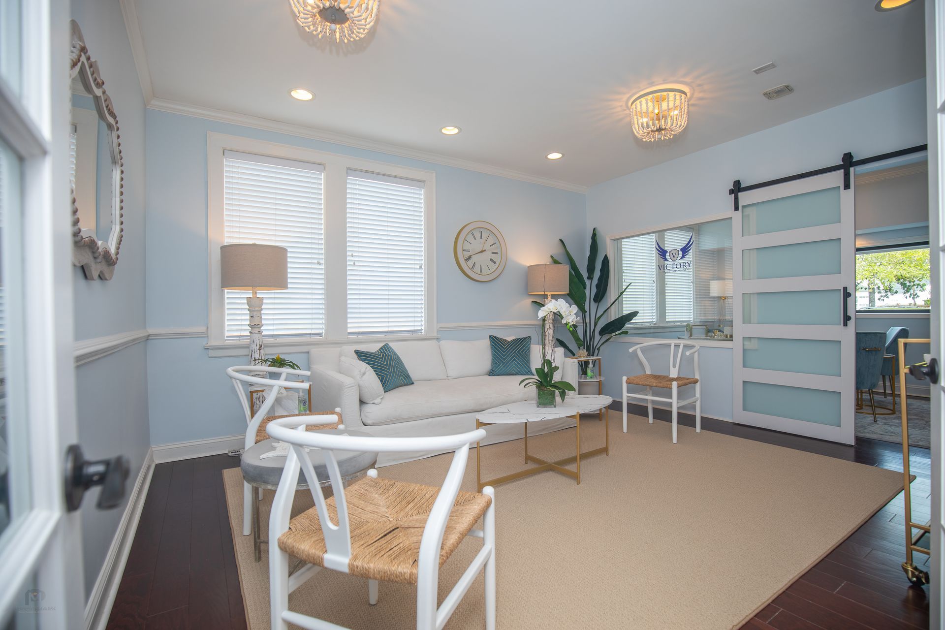 Living room with light blue walls, white sofa, and modern furniture.