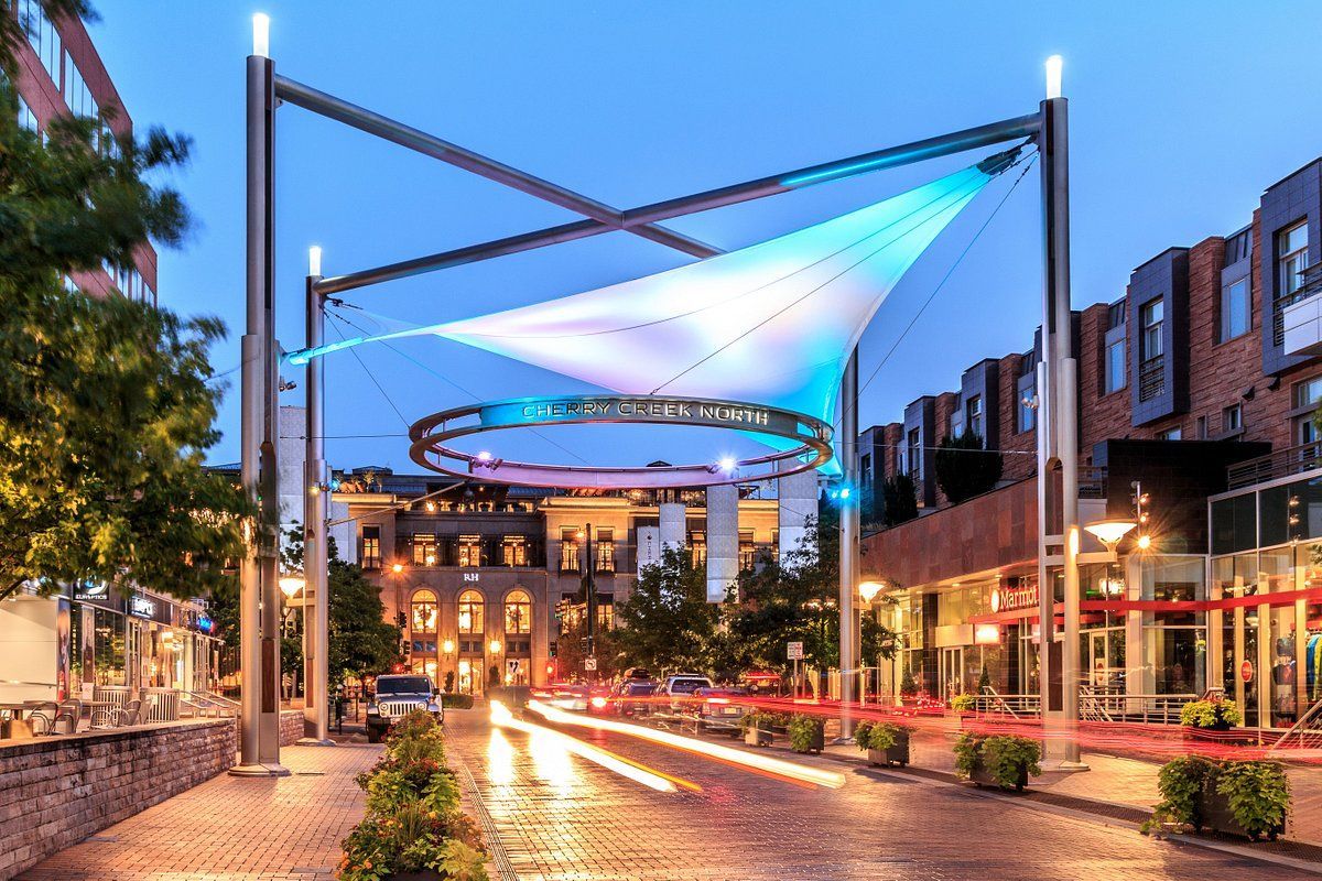 A city street at night with a large umbrella in the middle of it.