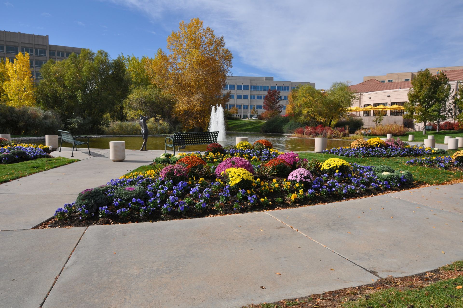 A park with flowers and a fountain in the background