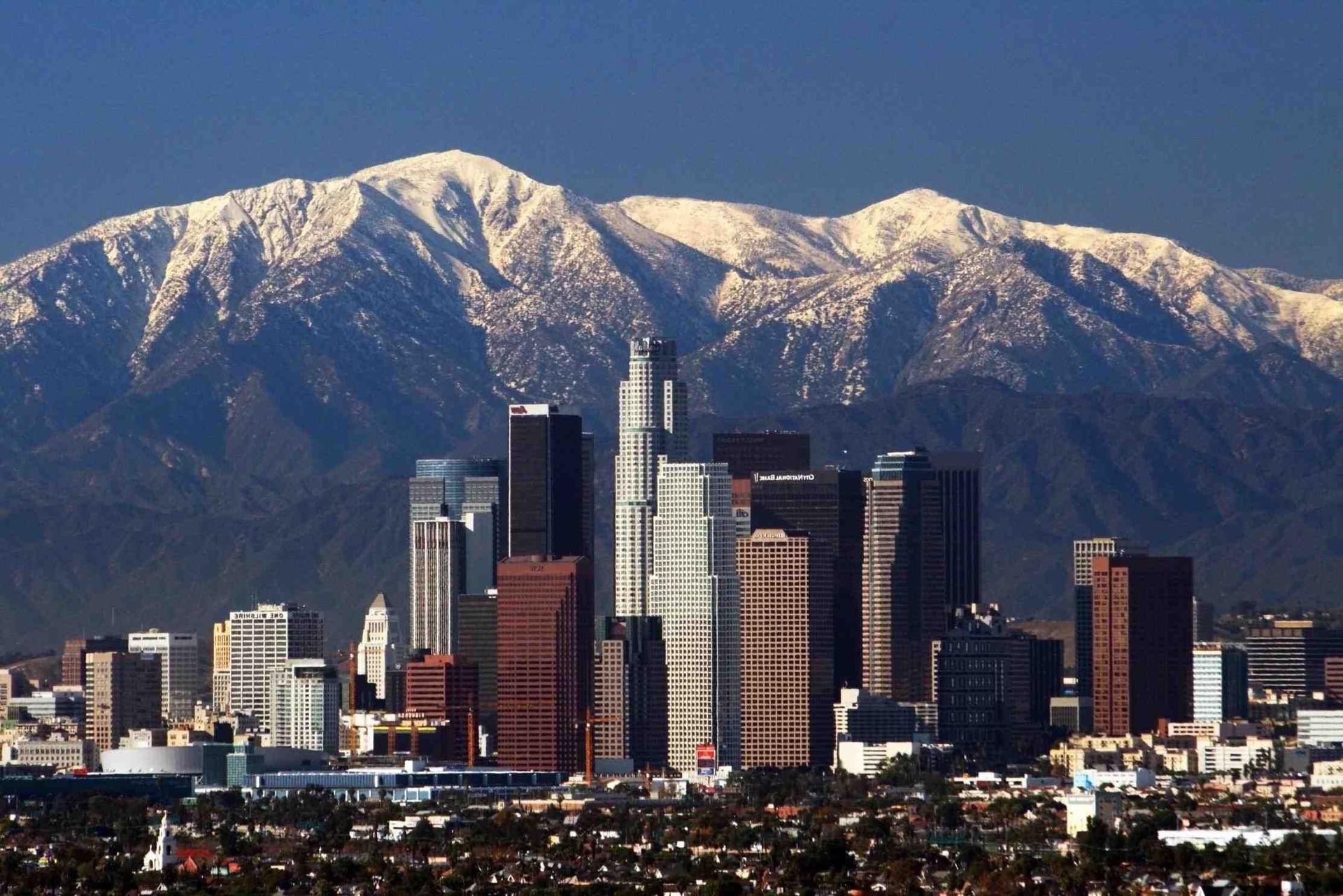 A city skyline with snowy mountains in the background