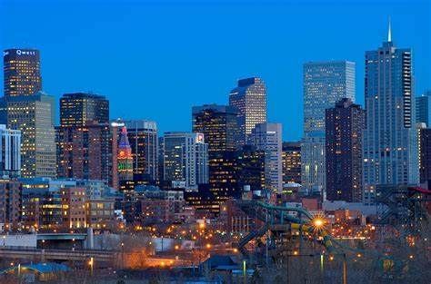 A city skyline at night with a bridge in the foreground