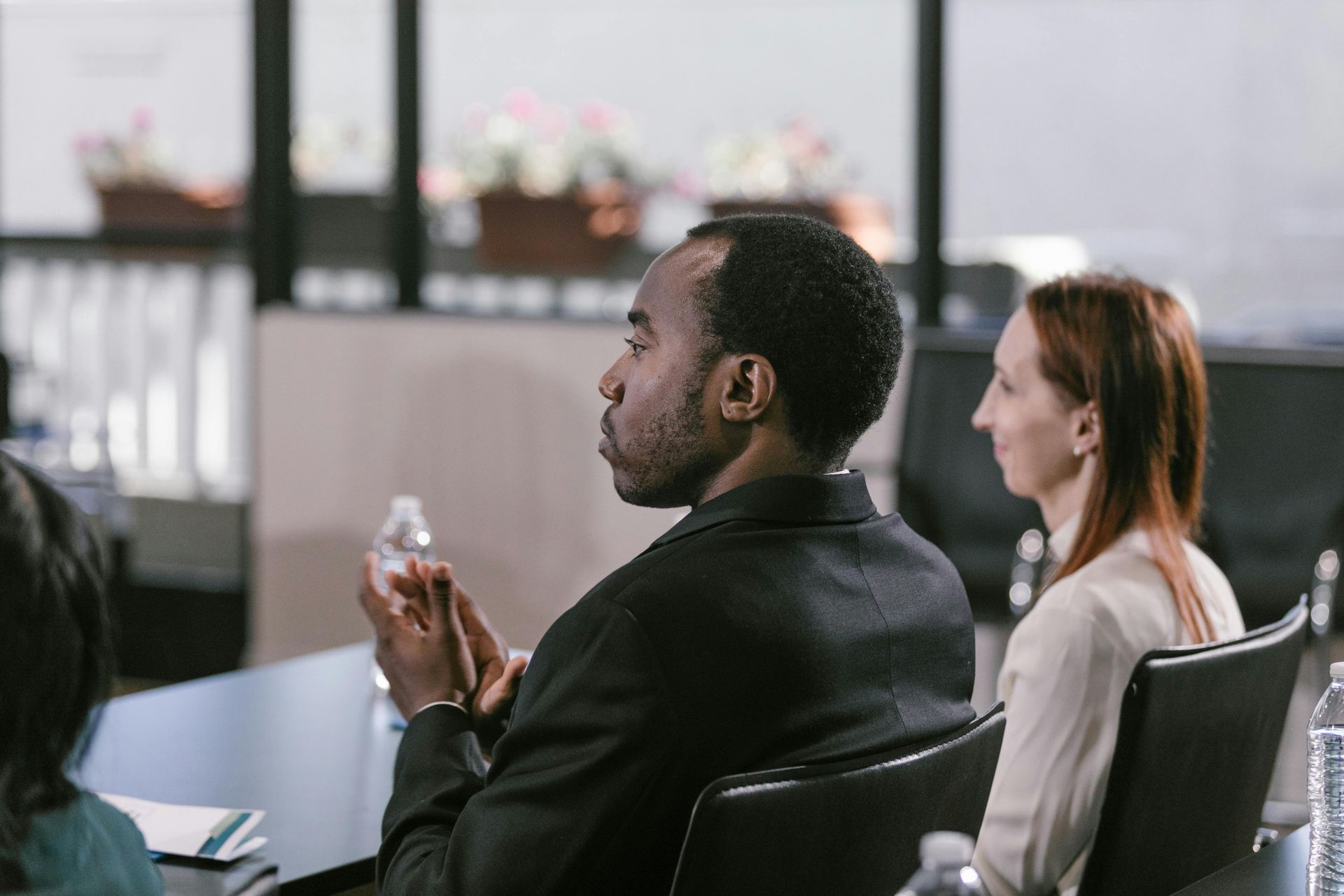 A group of people are sitting at a table in a conference room.