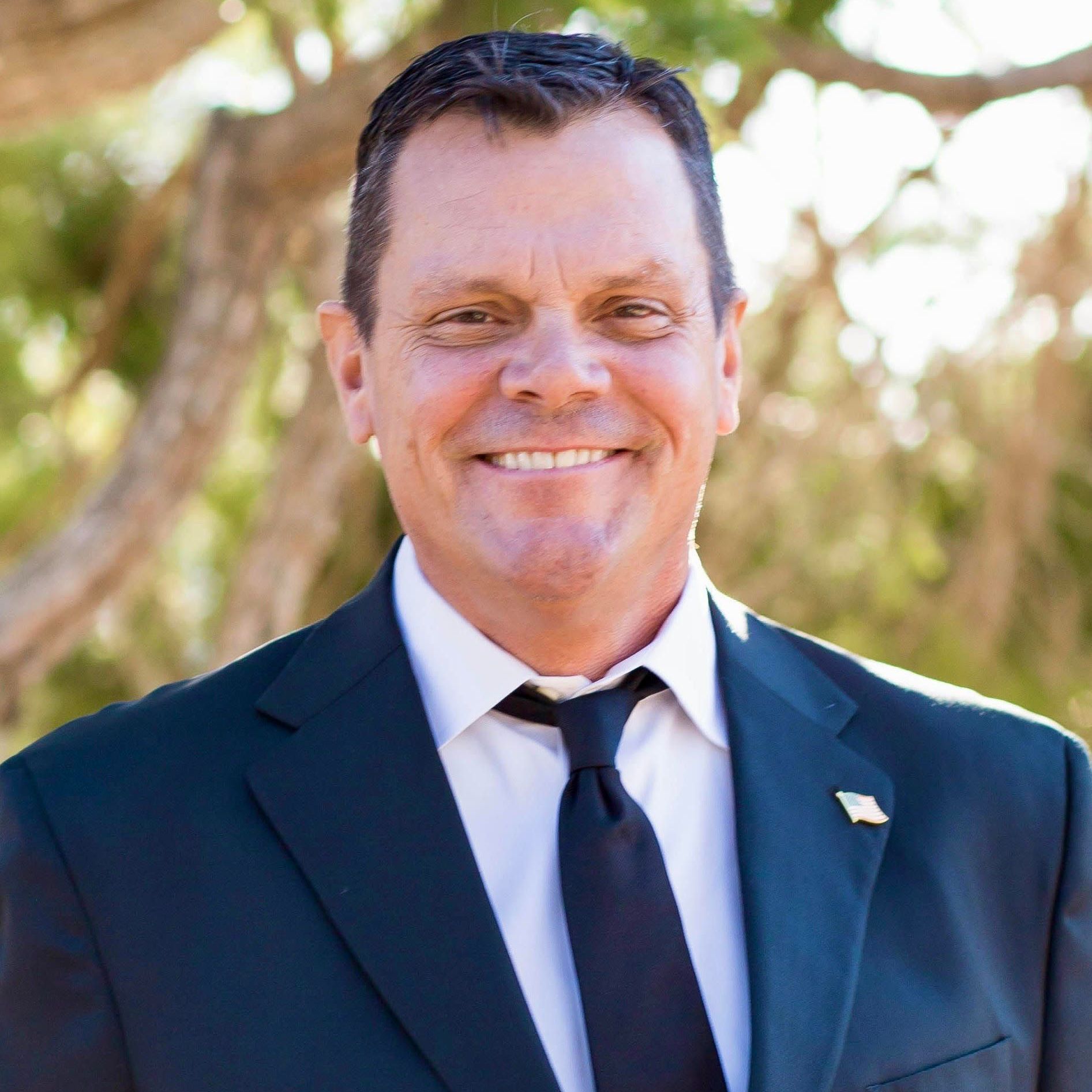 A man in a suit and tie is smiling for the camera.