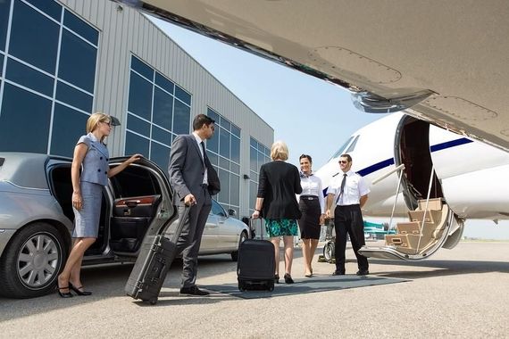 A group of people are standing in front of a private jet.