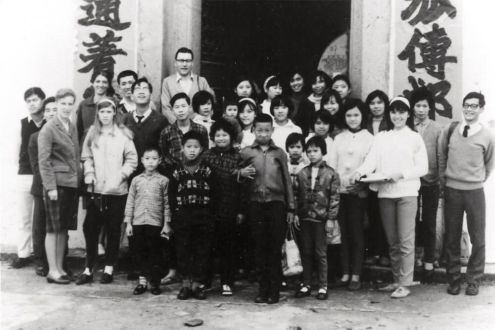 A group of people standing in front of a building with chinese writing on it