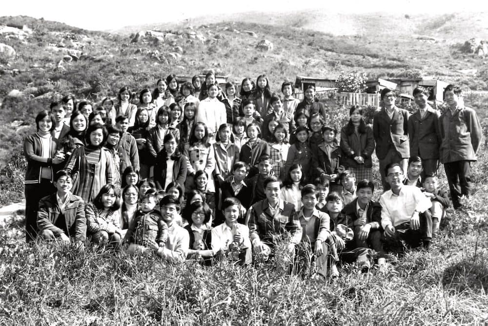 A large group of people are posing for a picture in a field.