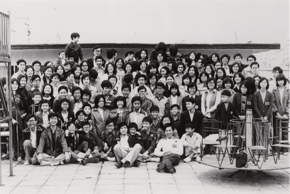 A large group of people are posing for a picture in a black and white photo.