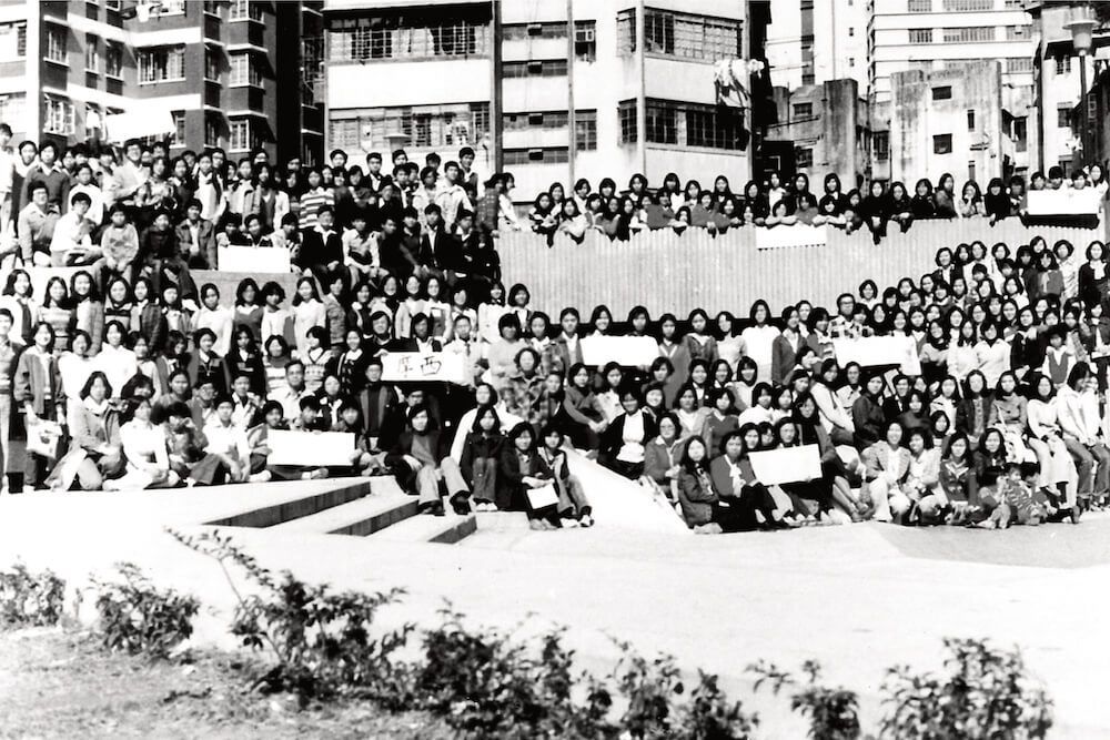 A black and white photo of a large group of people holding signs