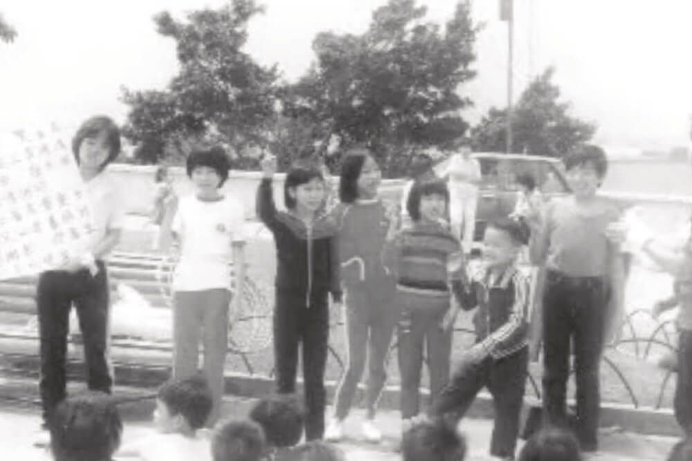 A group of children are standing next to each other in a black and white photo.
