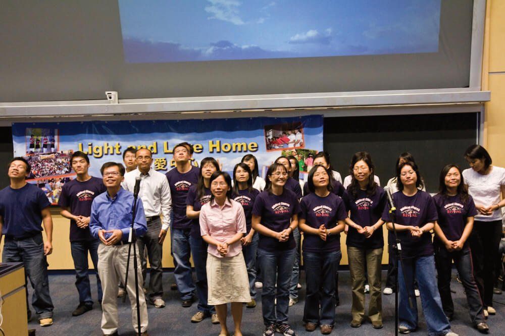 A group of people standing in front of a sign that says light and love home