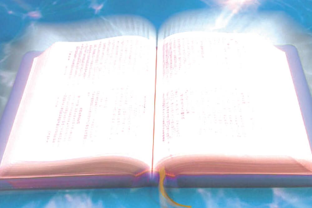 An open bible with a light coming out of it