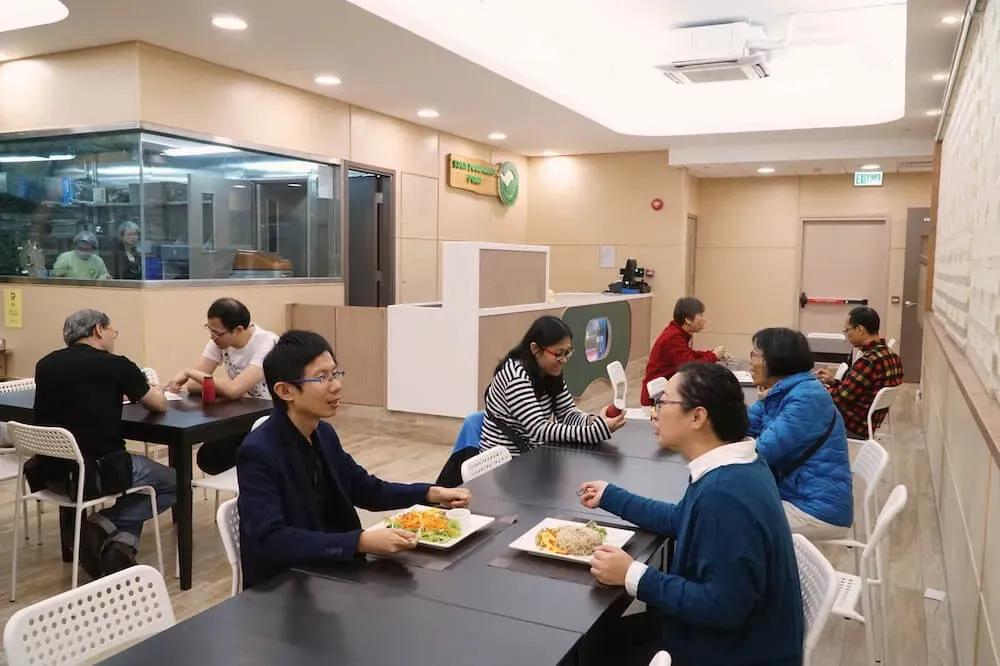 A group of people are sitting at tables in a restaurant eating food.