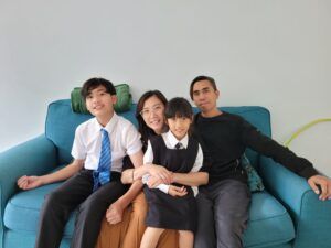 A family is posing for a picture while sitting on a blue couch.