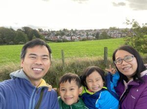 A family is posing for a picture in front of a field.