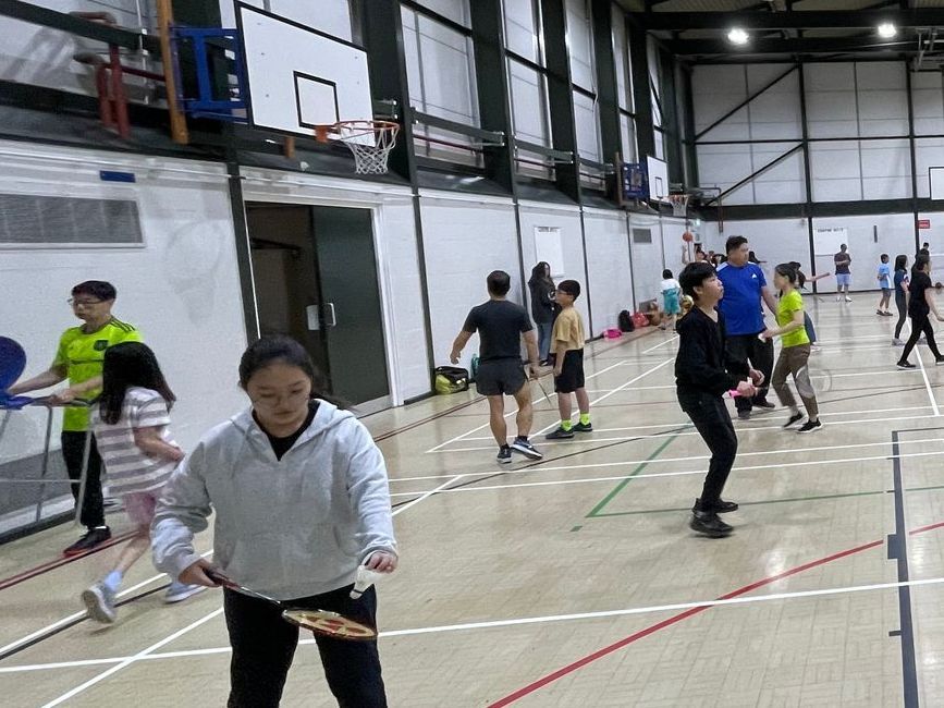 一群人正在健身房裡打羽毛球。