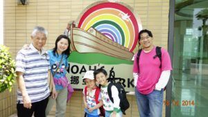 A group of people are posing for a picture in front of a sign that says noah 's ark.