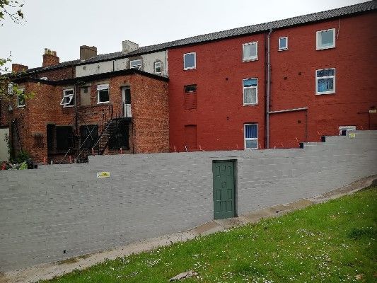 一棟紅磚建築,前方有一扇綠色的門。