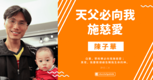 A man is holding a baby in front of an orange background with chinese writing