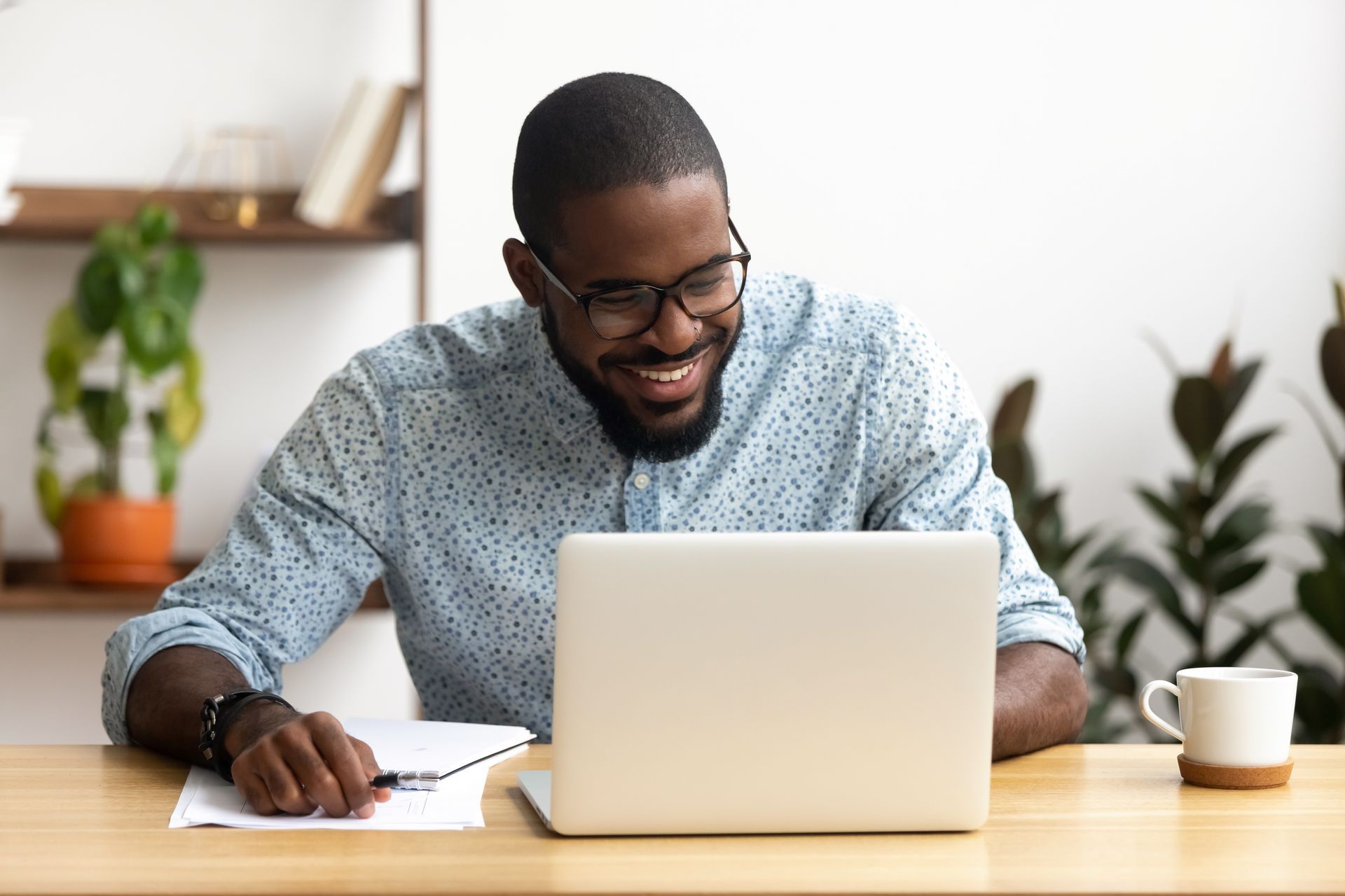 Man uses Bing from his laptop in an office setting with plants in background.