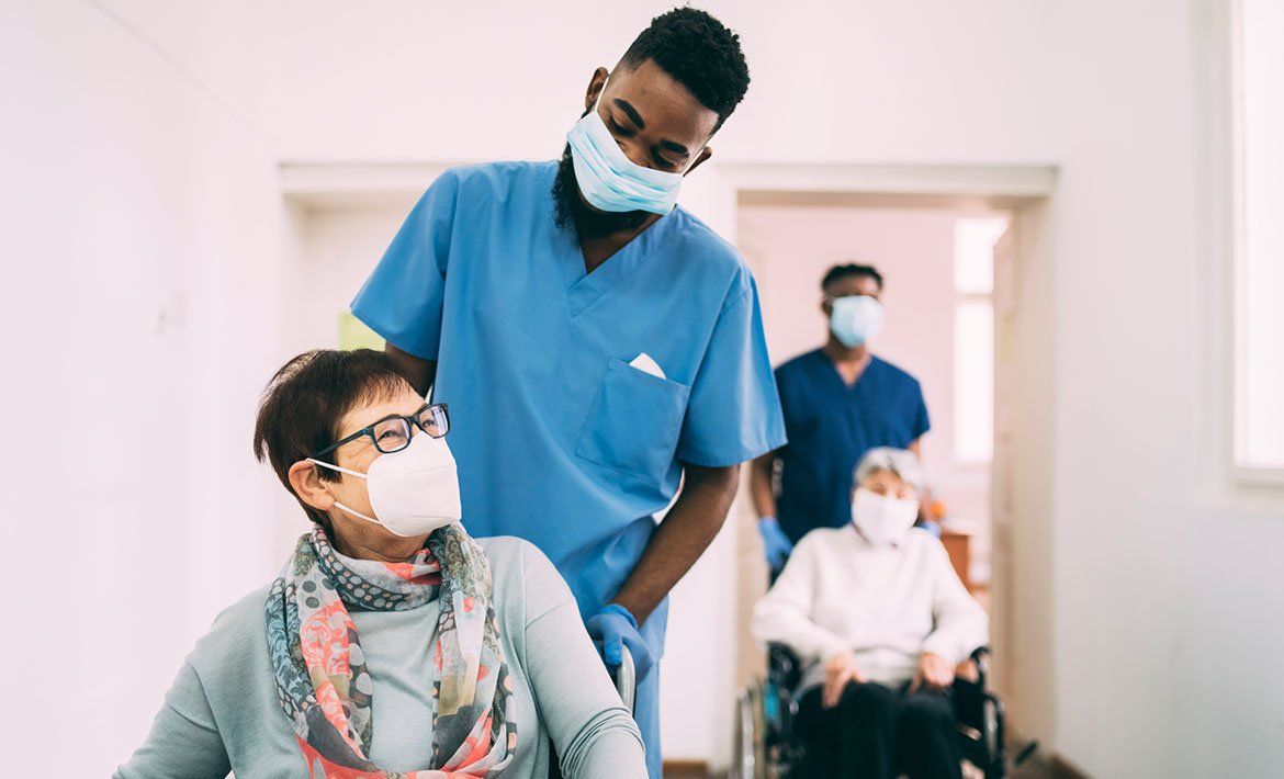 Nurse Assisting Patient On A Wheelchair — Jamestown, NC — Ashlen Staffing Solutions