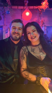 A man and a woman are posing for a picture in a dark room.