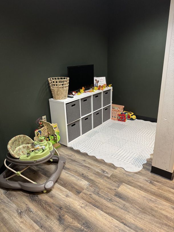 A baby walker is sitting in a room next to a television.