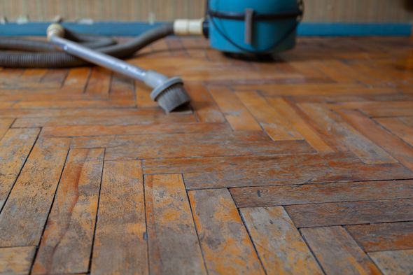 A vacuum cleaner is sitting on a wooden floor.